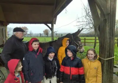 Enfants à l'abri de la pluie avec un âne