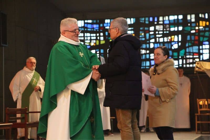 Le père Cador remet à deux baptisés des lettres de mission à l'église Saint-Liboire