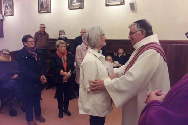 Le père Cador dans une chasuble violette remet à Anne-Laure Restout une lettre de mission à Notre Dame de La Couture