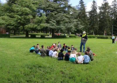 Un groupe de jeunes assis dans la prairie écoutent un adulte dans le cadre d'un atelier sur les vocations