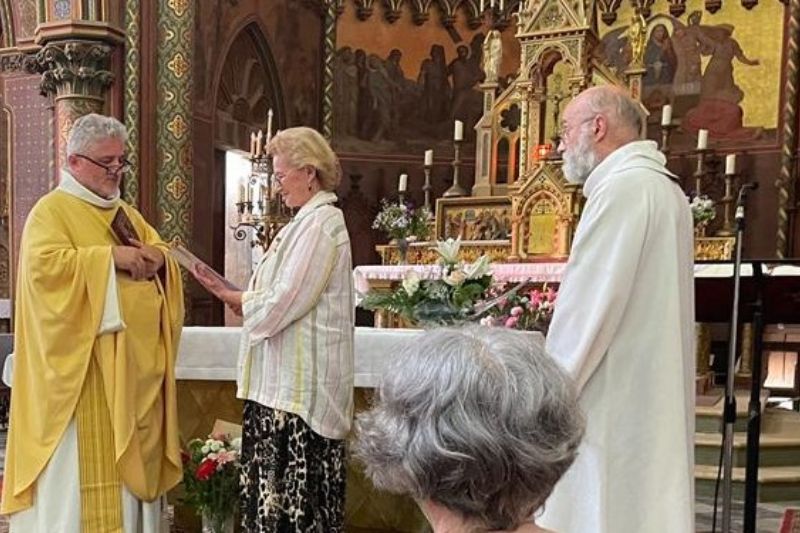 Le père Cador dans une chasuble violette remet à Anne-Laure Restout une lettre de mission à Notre Dame de La Couture